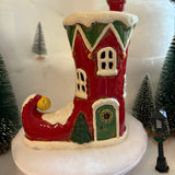 Decorative house on a snowman with Christmas trees in the background